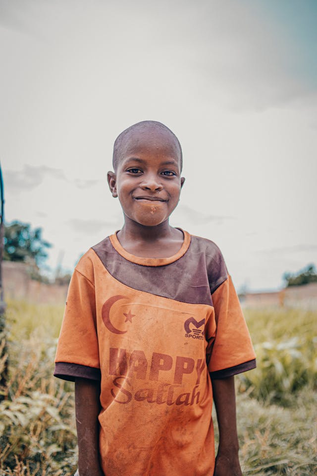 A child looks directly at the camera with a calm, hopeful expression