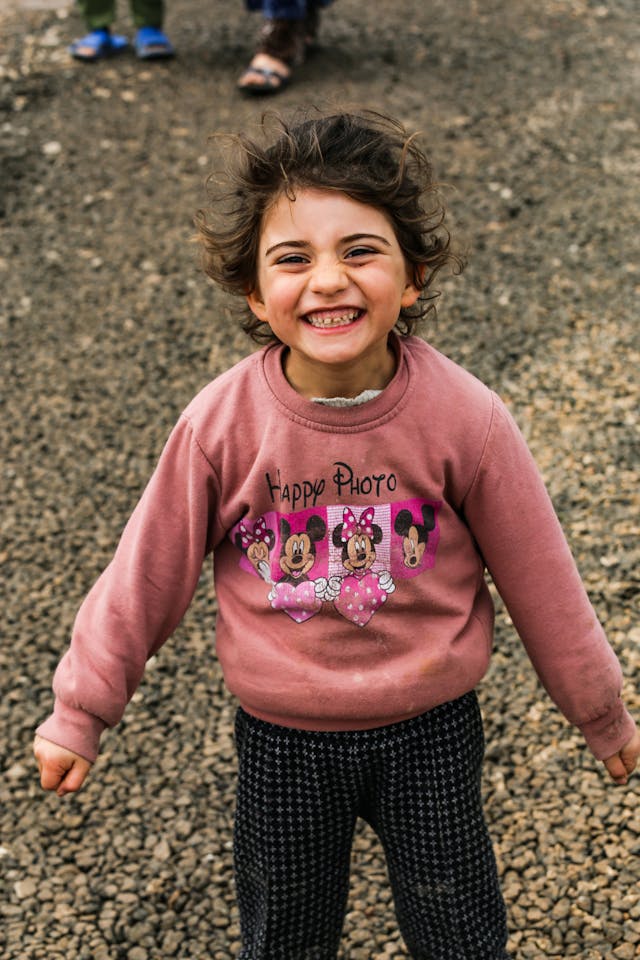 A child sits thoughtfully, reflecting the dignity at the heart of our work